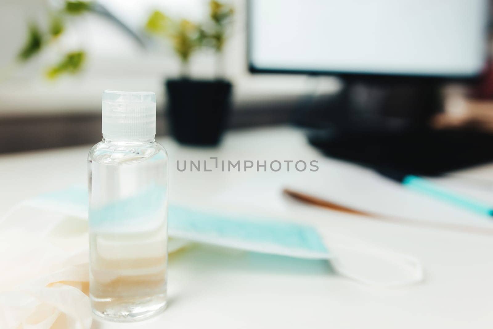 Sanitizer and blue mask on the table. High quality photo