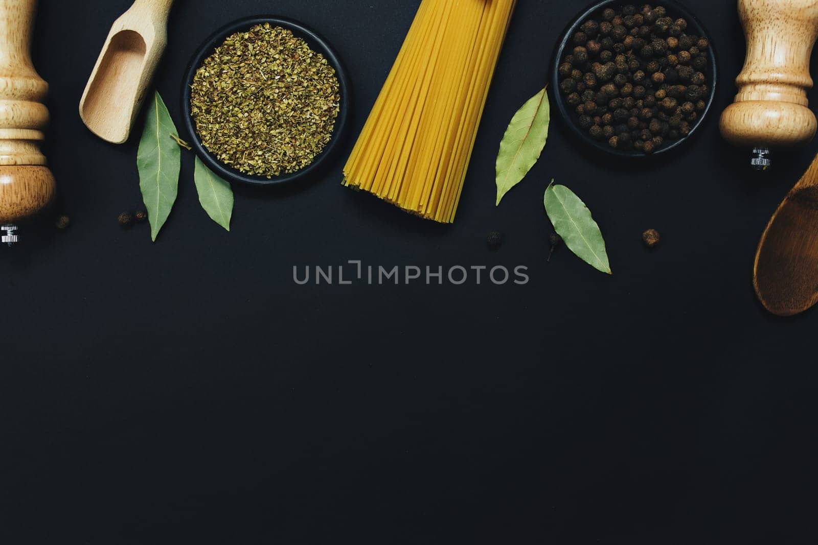 Seasonings, herbs and pasta on black background. High quality photo