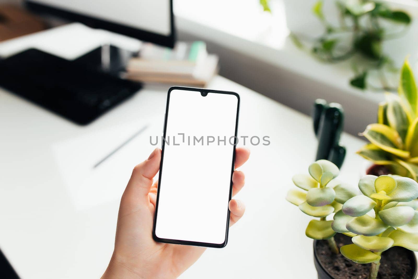Smartphone in the hand, work from home, office stuff. High quality photo