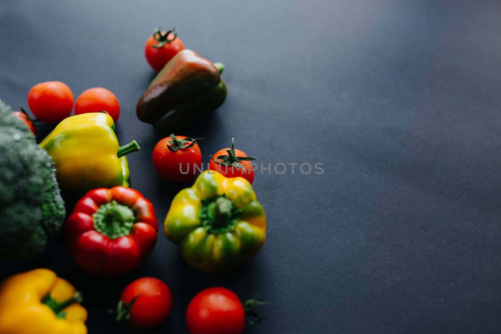 Fresh green broccoli and other vegetables, drops of water on broccoli. Gray background. High quality photo