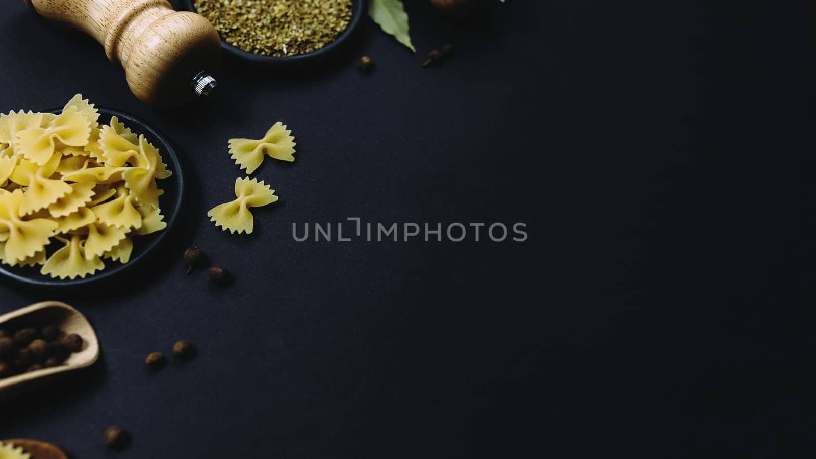 Seasonings, herbs and pasta on black background. High quality photo