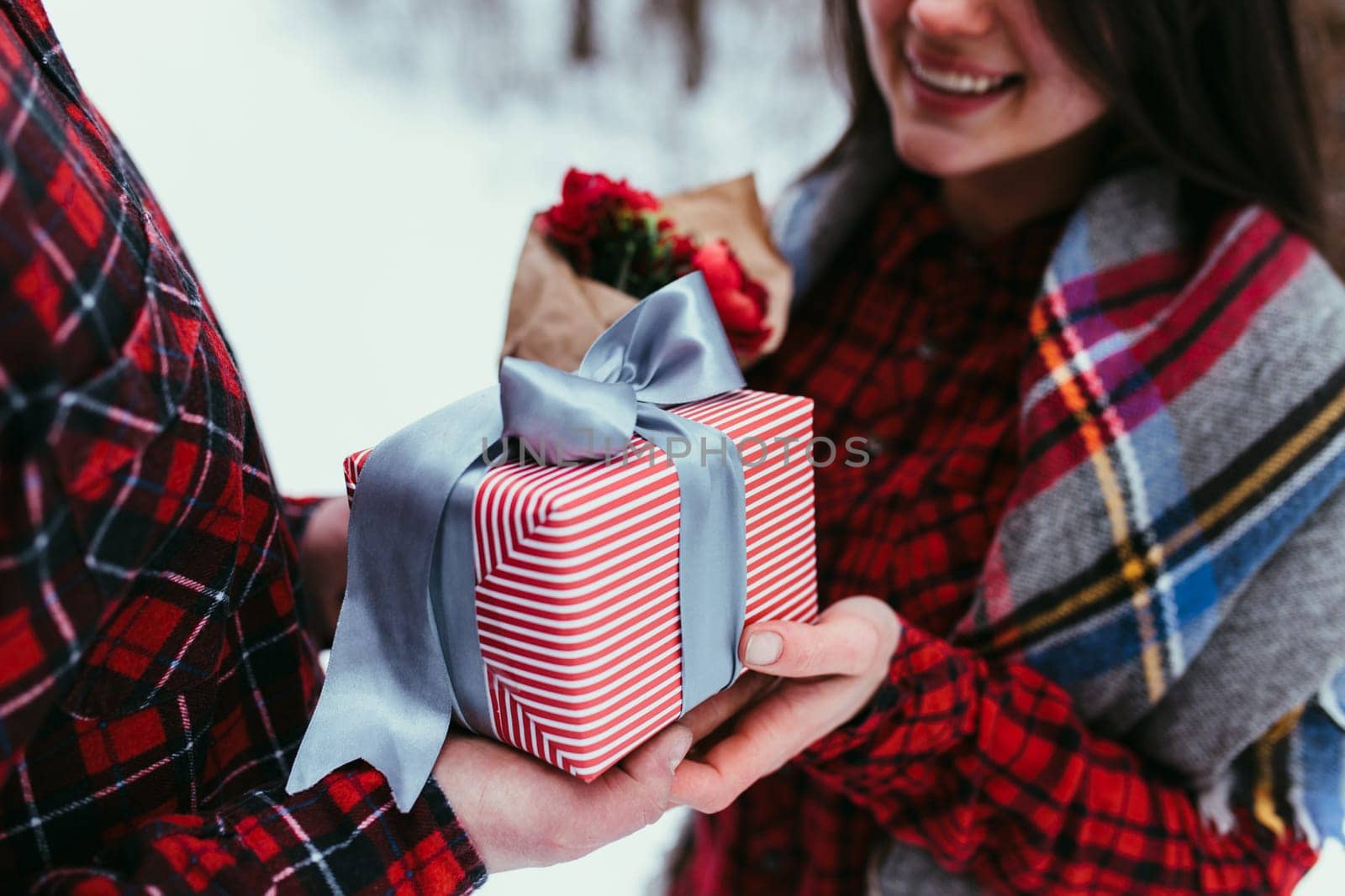 Hands giving a gift box with ribbon. Blurred background. High quality photo