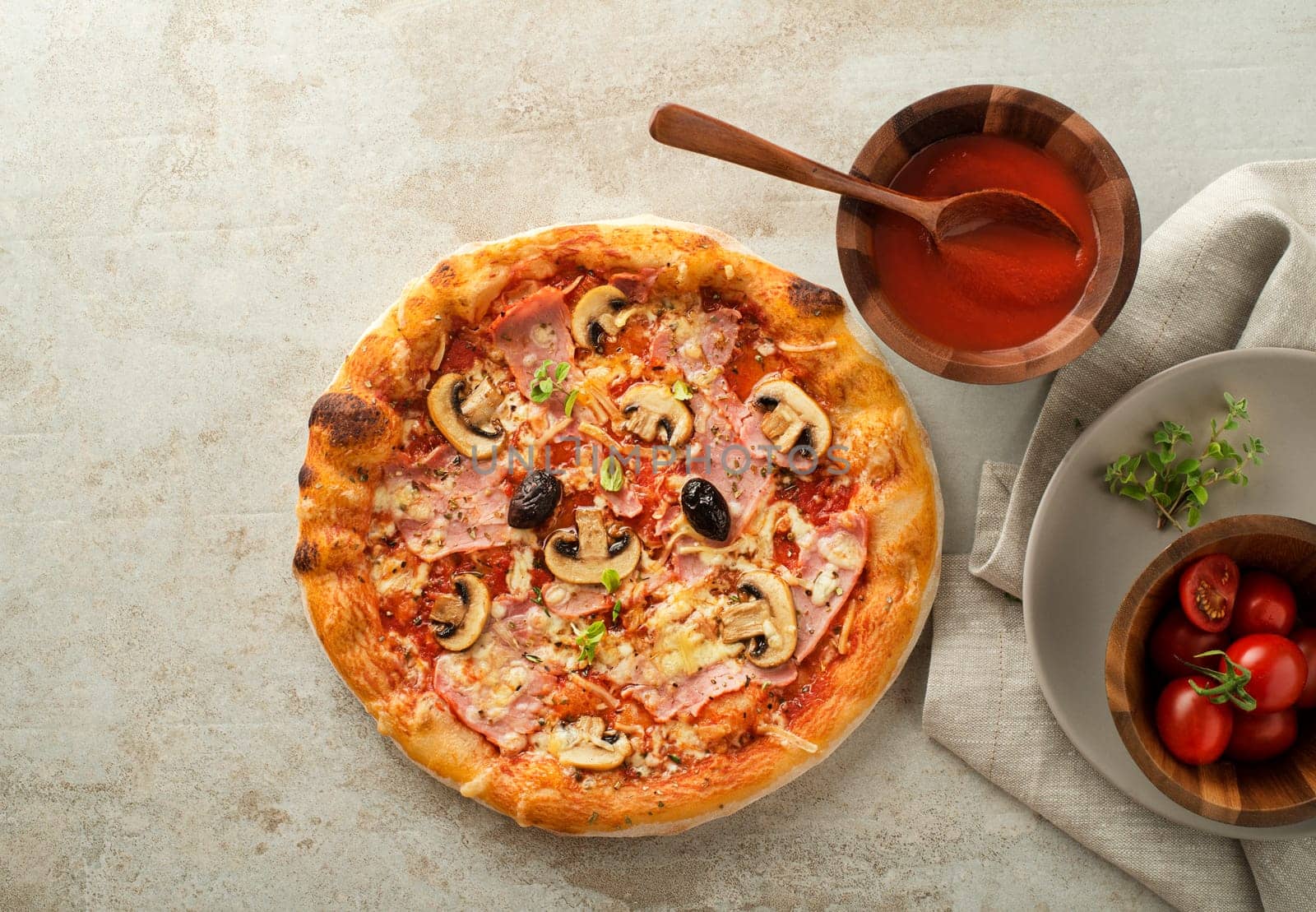 Pizza served with cheese, ham, mushrooms, olives  and tomato sauce