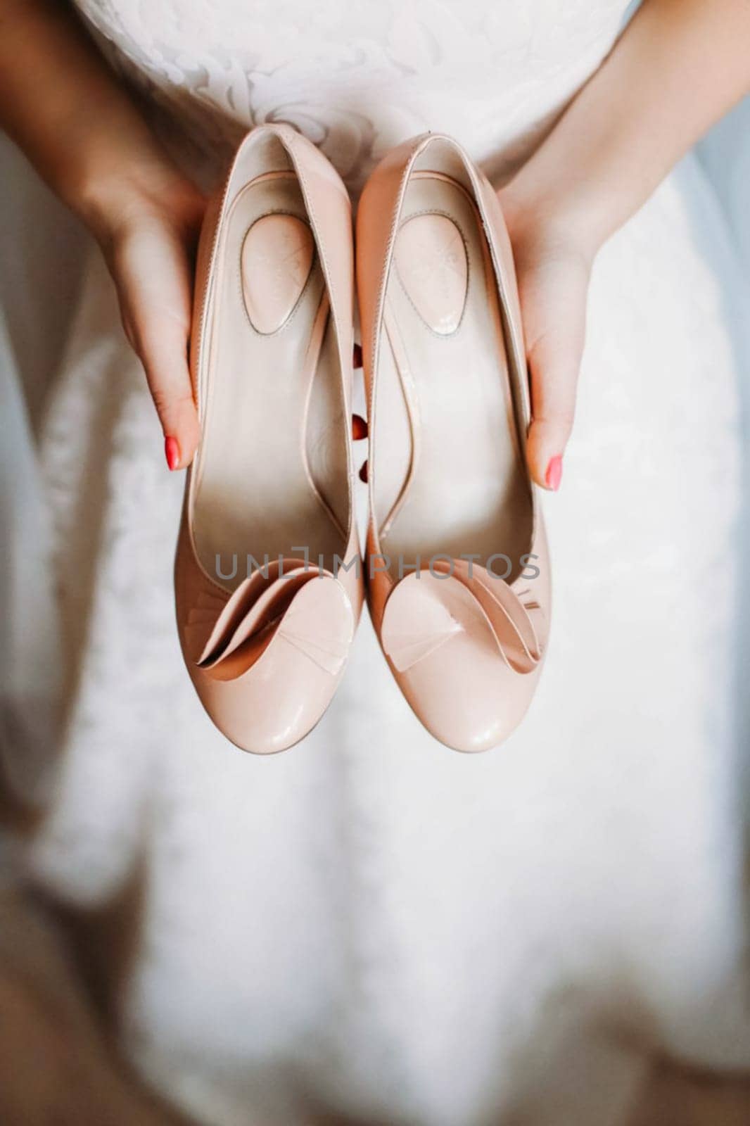 The bride is holding white shoes. Preparing for the wedding.