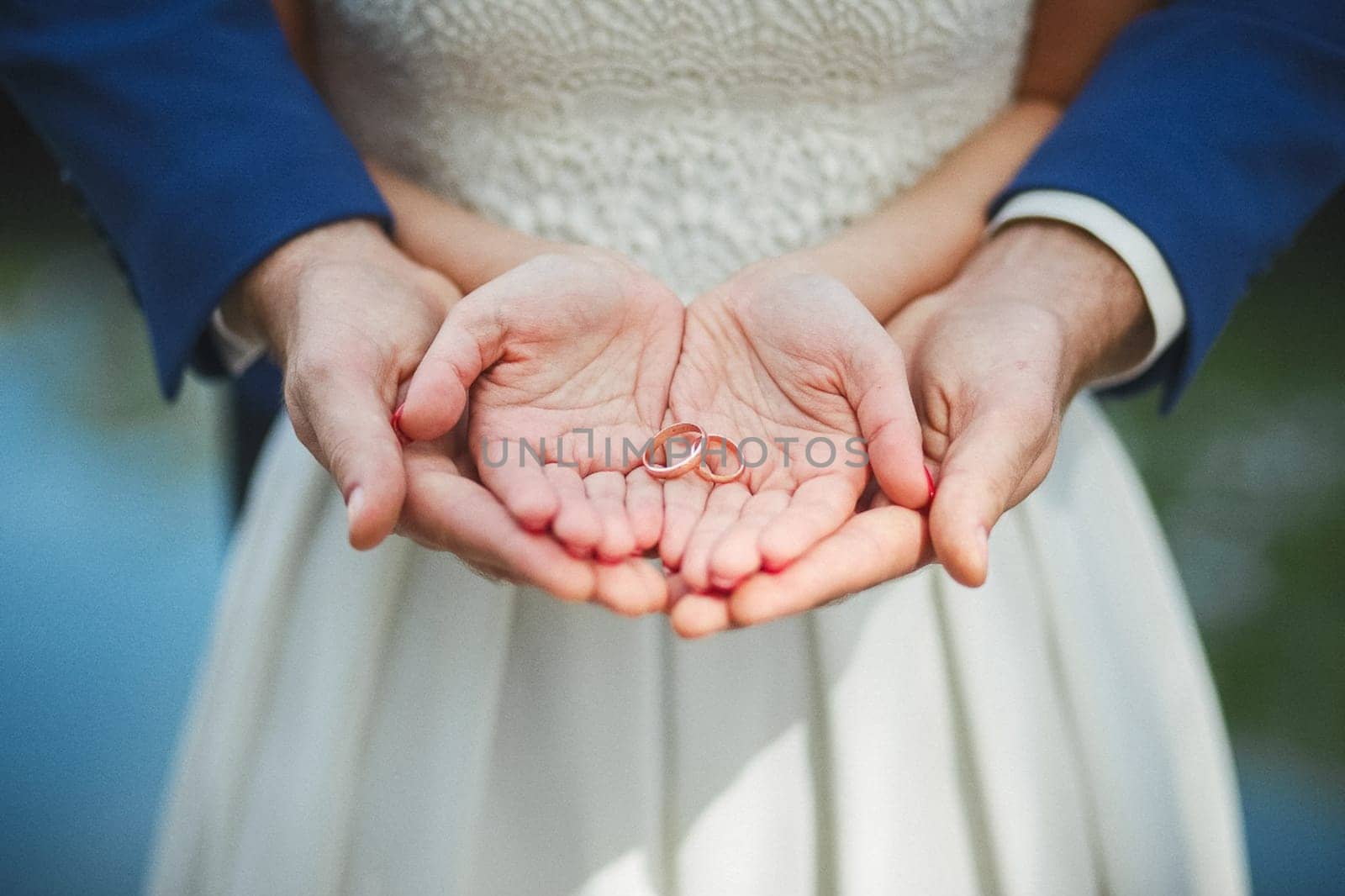 The bride and groom hold rings in their palms. Wedding.