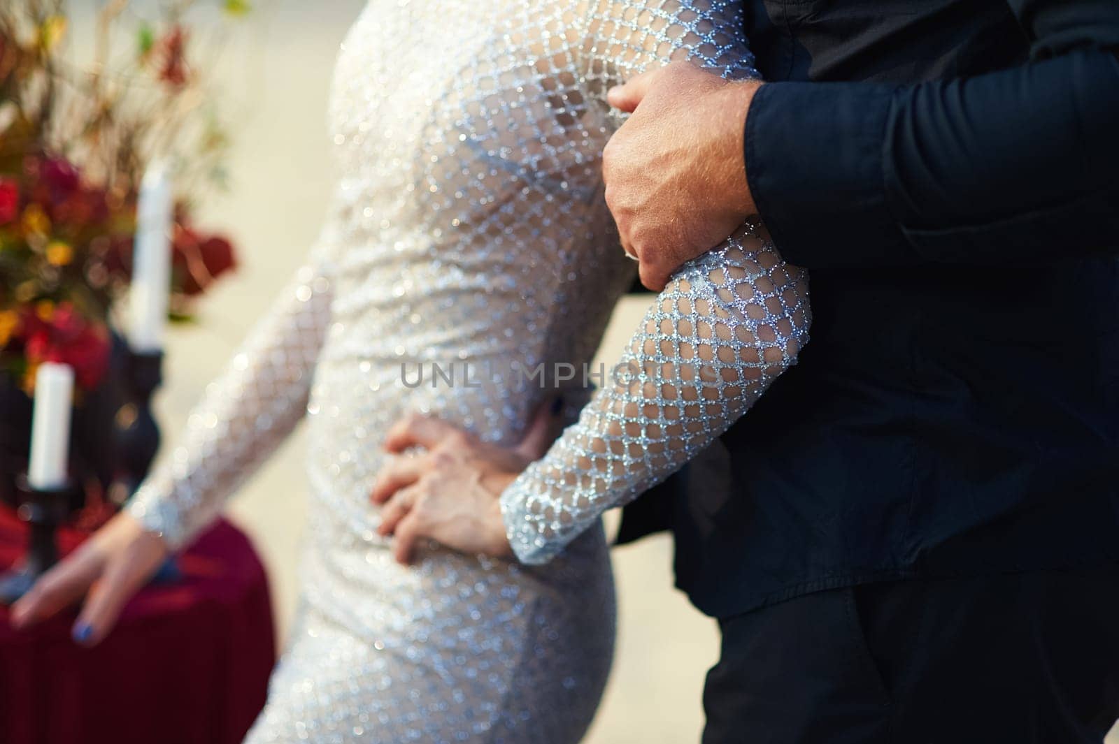 The groom holds the weight by the arm. Wedding photo.