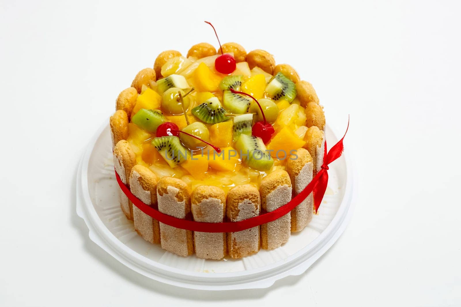 Cake with kiwi cherries and pineapple. Cake on a white background