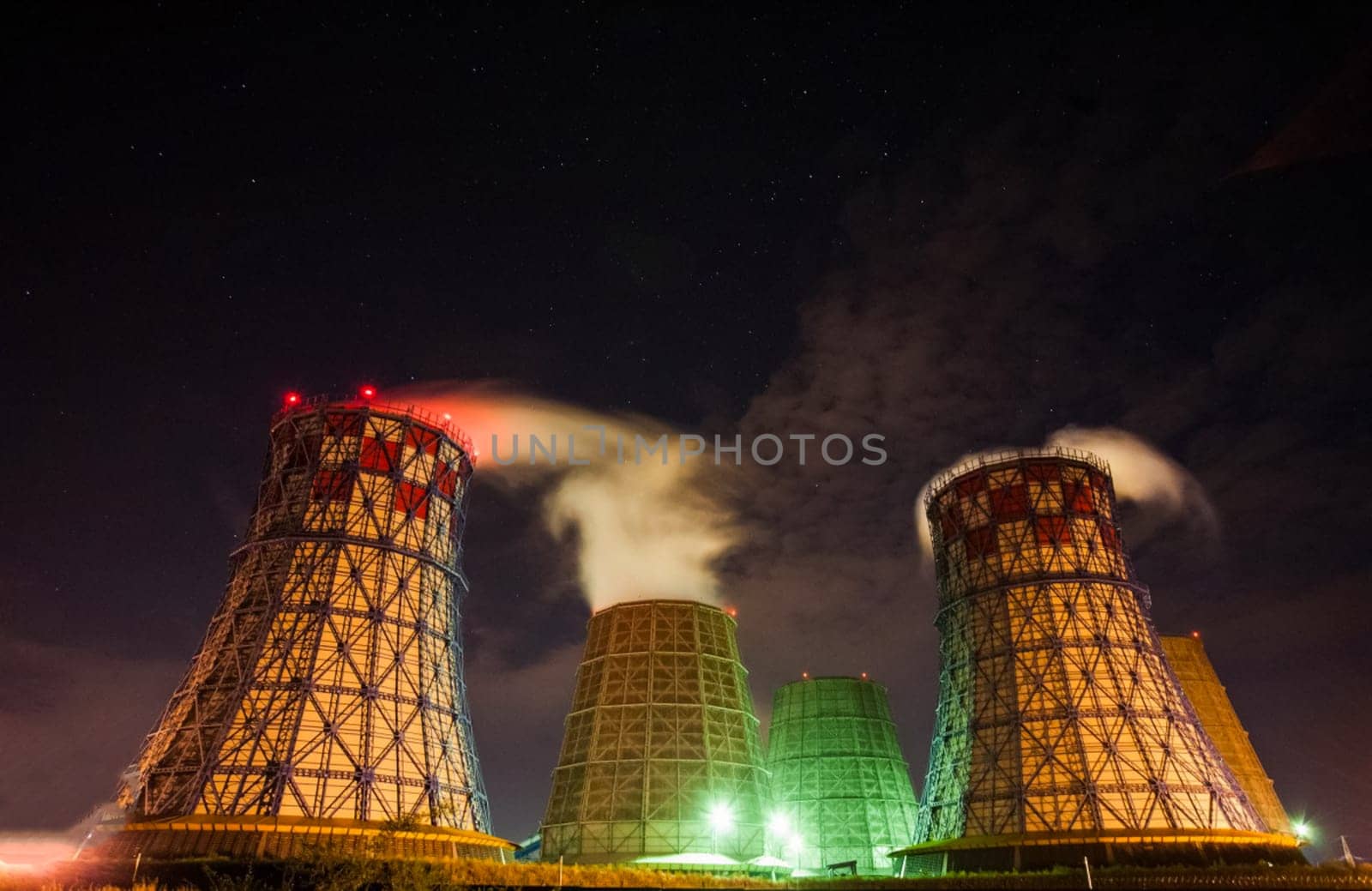 The cooling towers of the nuclear power plant. Wide pipes from which the steam rolls.