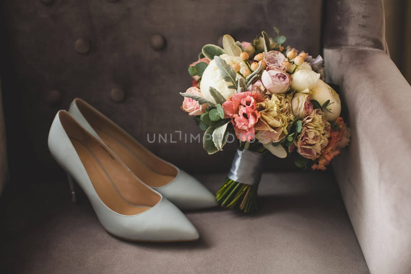 White bride shoes and a bouquet of flowers.