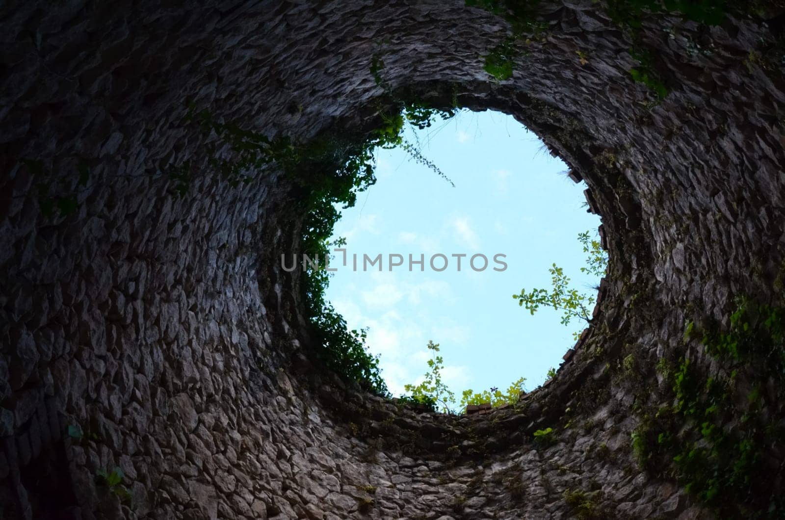 View from the water well from the bottom up. The stone walls of the well