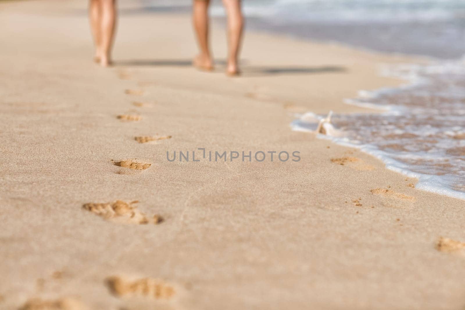 Traces on the sandy shore of the sea from people walking.