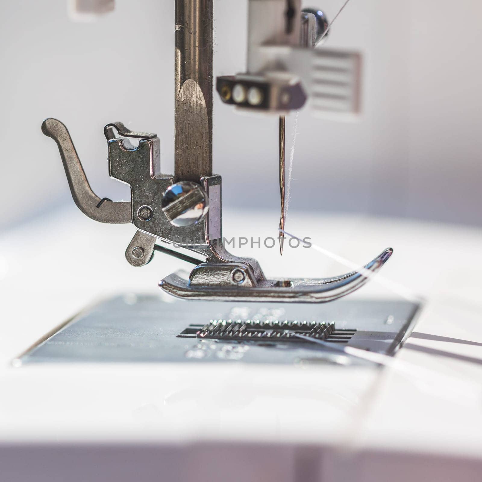 Close up of sewing metal sewing needle with sewing thread