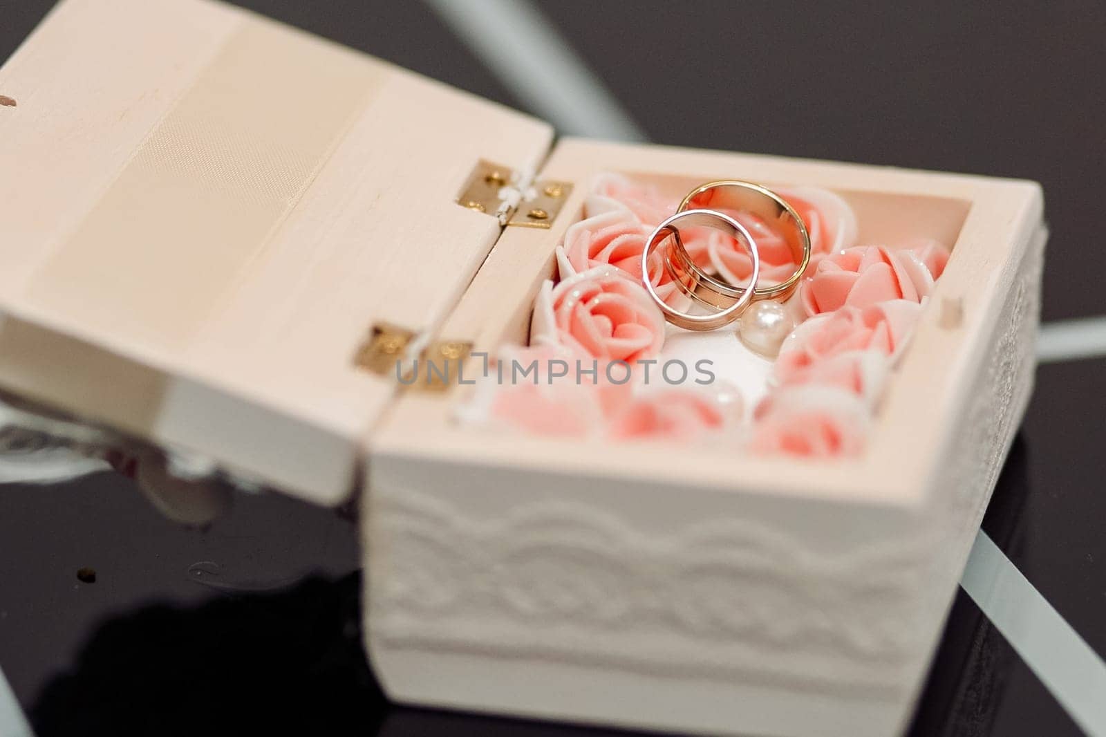 Wedding rings in a white casket. With flowers