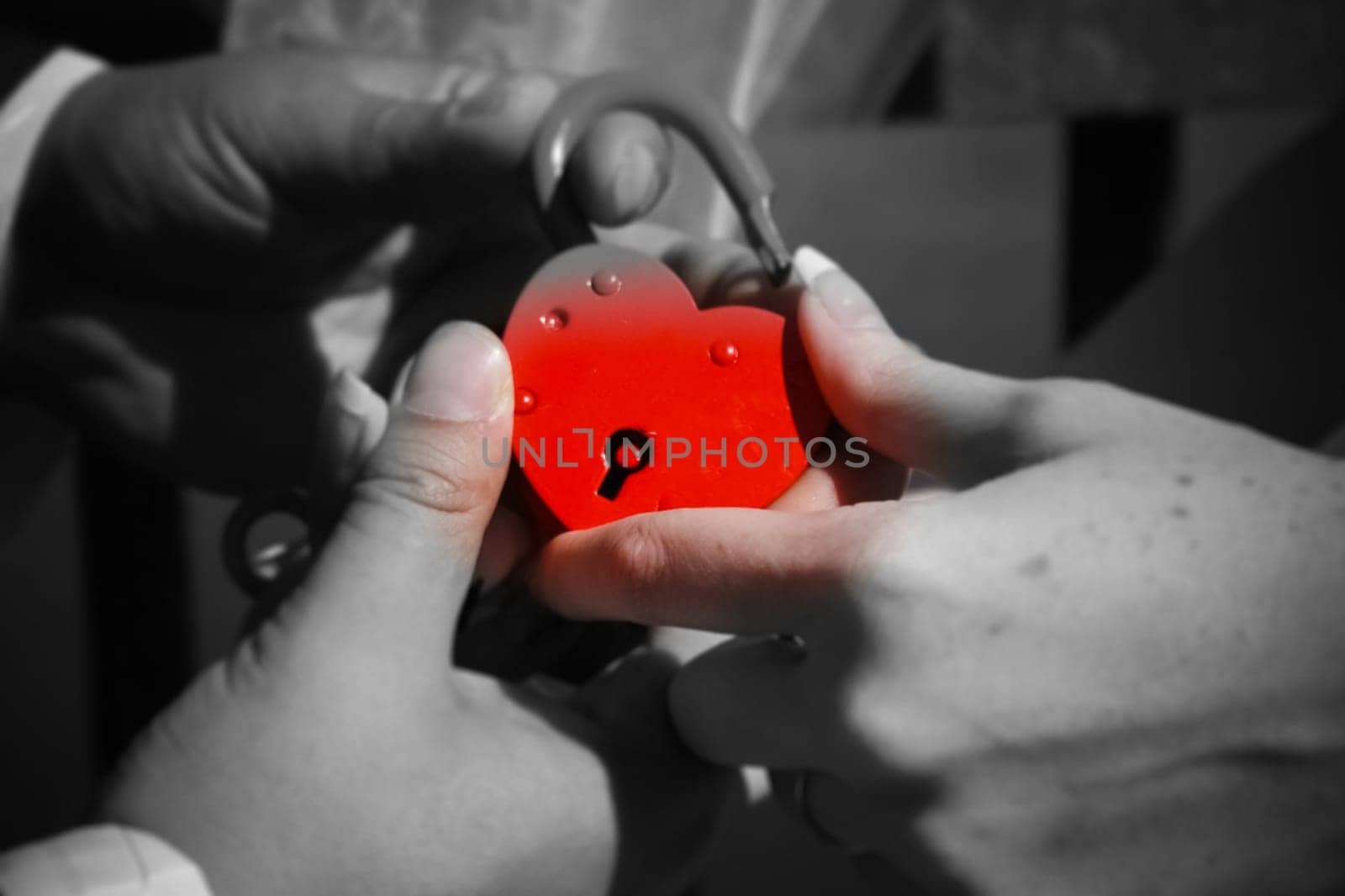 The newlyweds hold a red lock in their hand. Wedding.