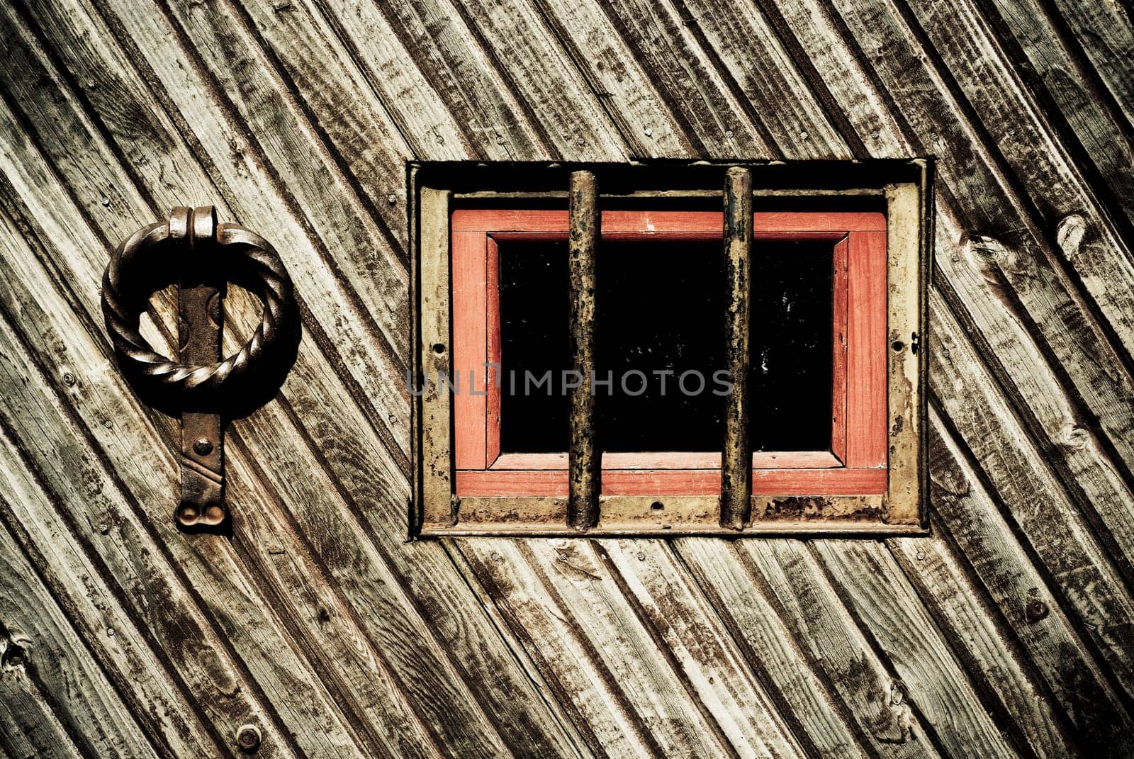 Close_up of a window with knocker on a wooden door