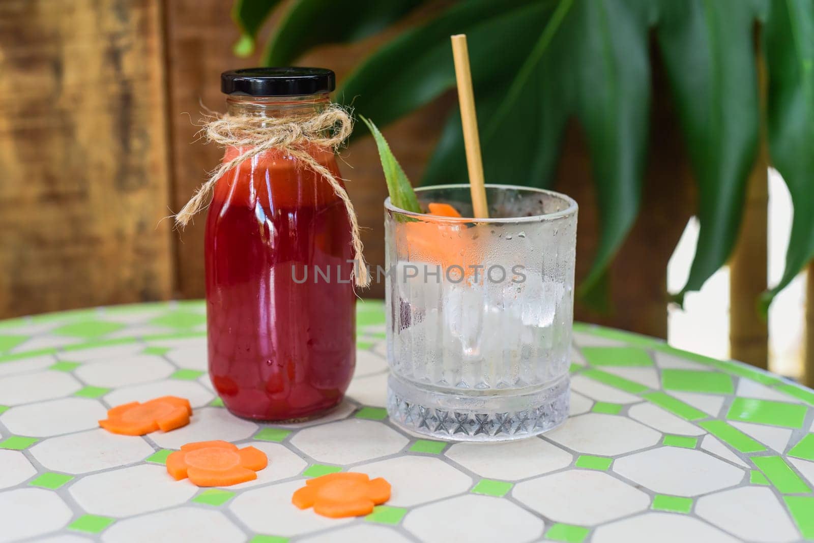 Healthy mixed juice made of carrot, orange fruit, pink dragon fruit, apple with glass with ice