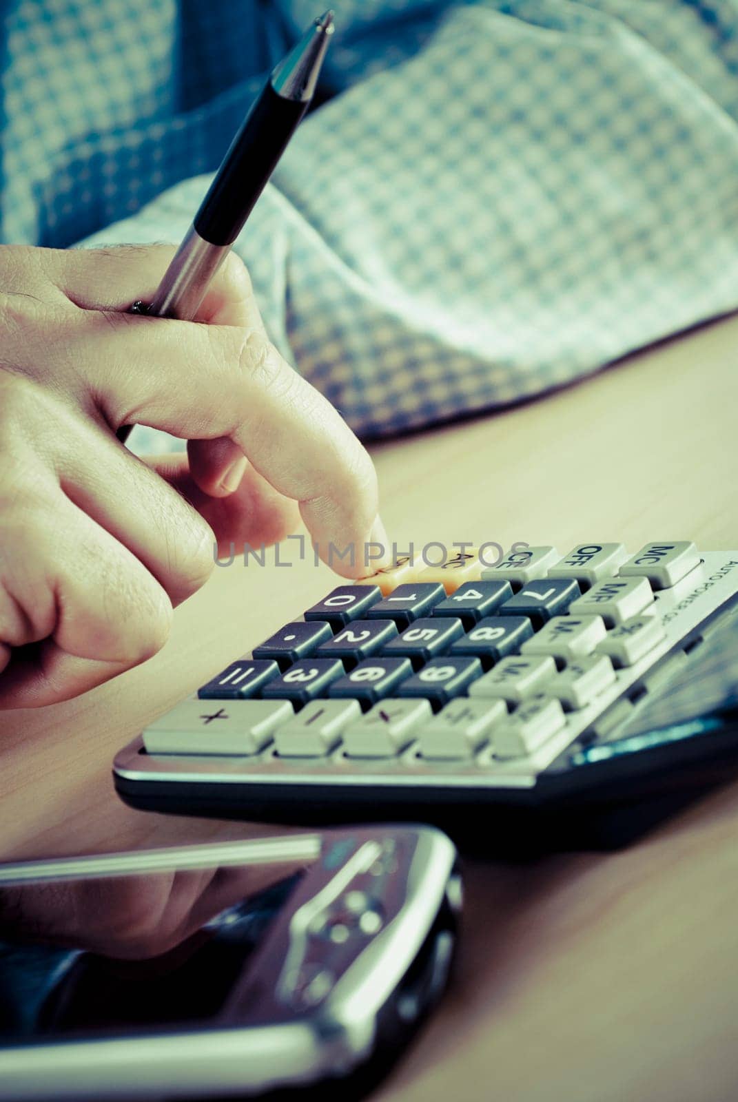 Close_up of a manŽs hand using a calculator