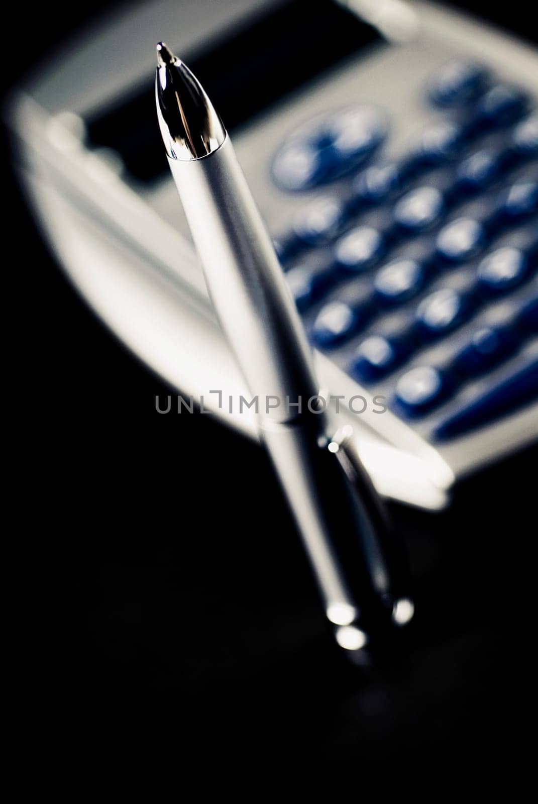 Close_up of a pen and a calculator