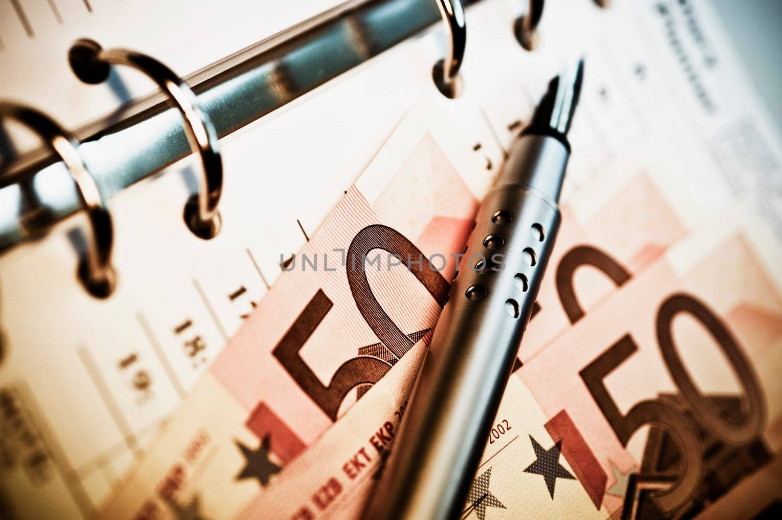European union banknotes with a pen over a spiral notebook