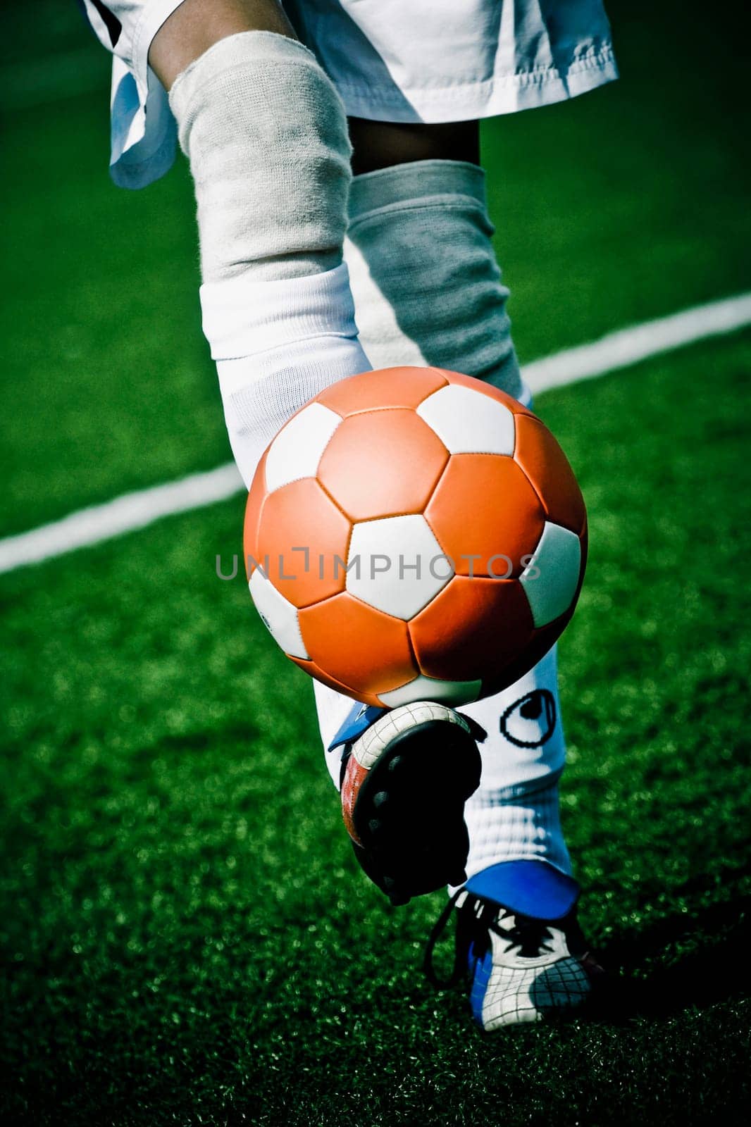 Low section view of a person kicking a ball