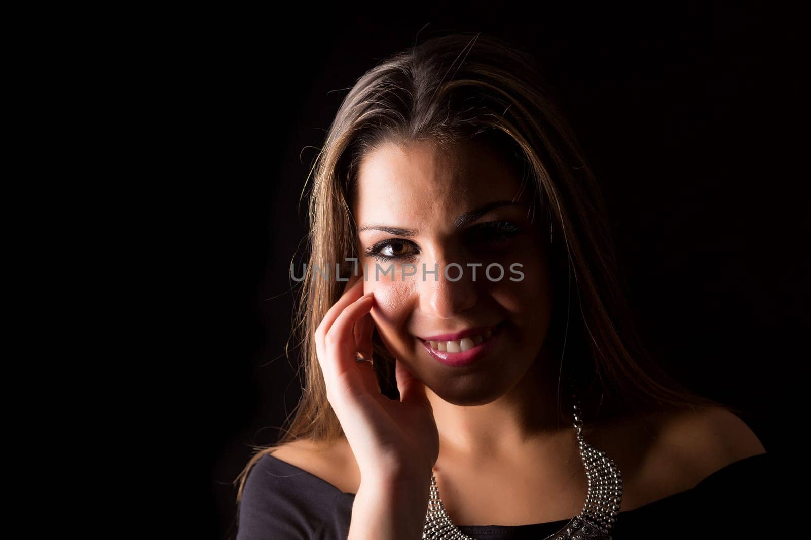 Young beautiful woman standing against black background