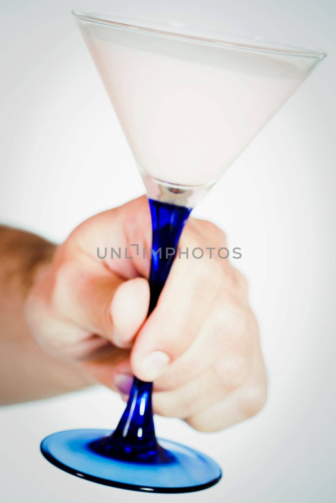 Close_up of a personŽs hand holding a martini glass