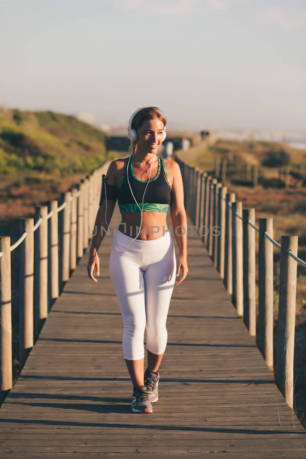 Young beautiful chinese woman exercising at the beach at sunrise/sunset
