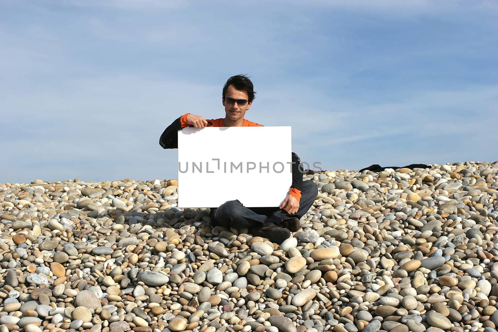 Young Man Holding White Card at the beach