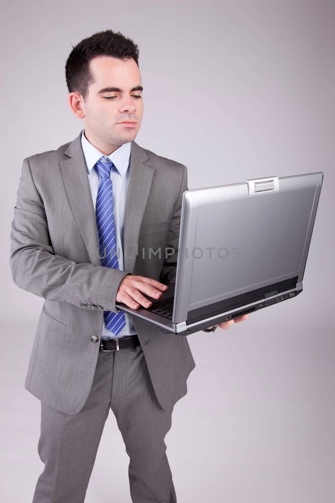 Young business man working with laptop, isolated