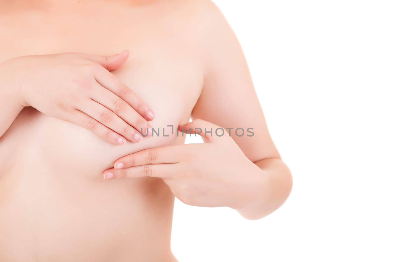 Young Caucasian adult woman examining her breast for lumps or signs of breast cancer