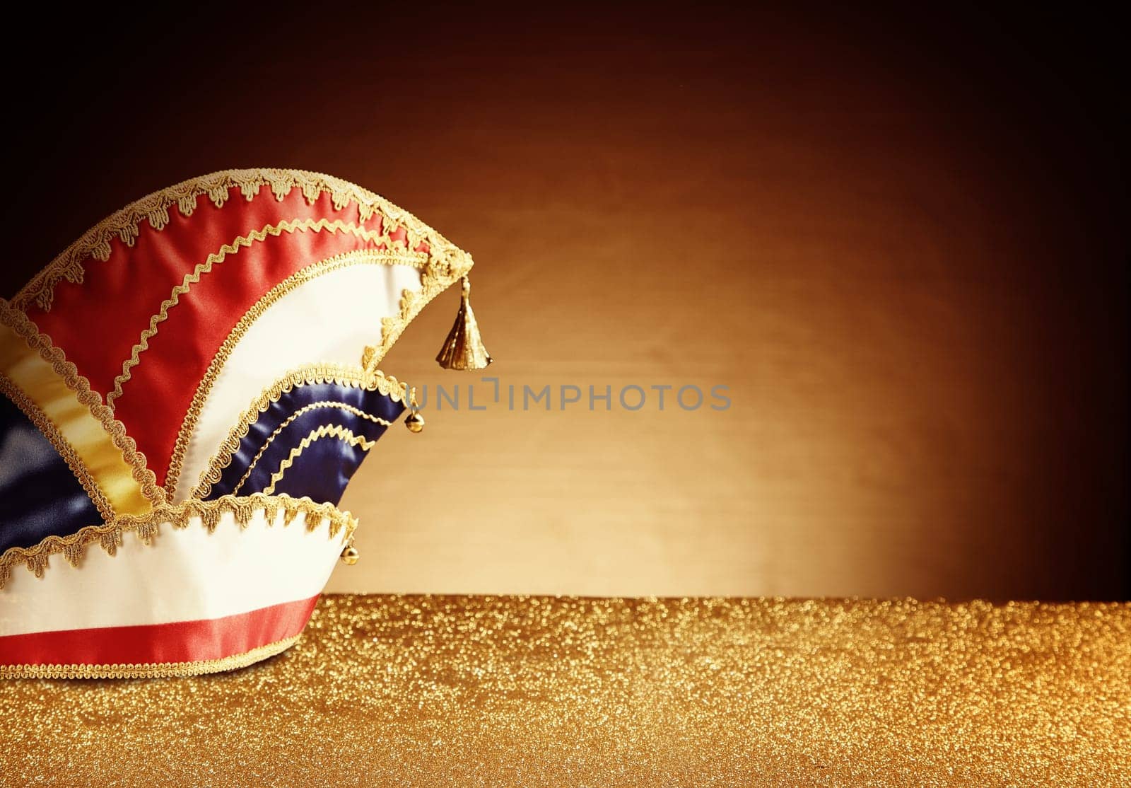 Close up Nice Carnival Hat on Top of Glittery Table in front Gradient Brown Background with Copy Space on the Right Side.