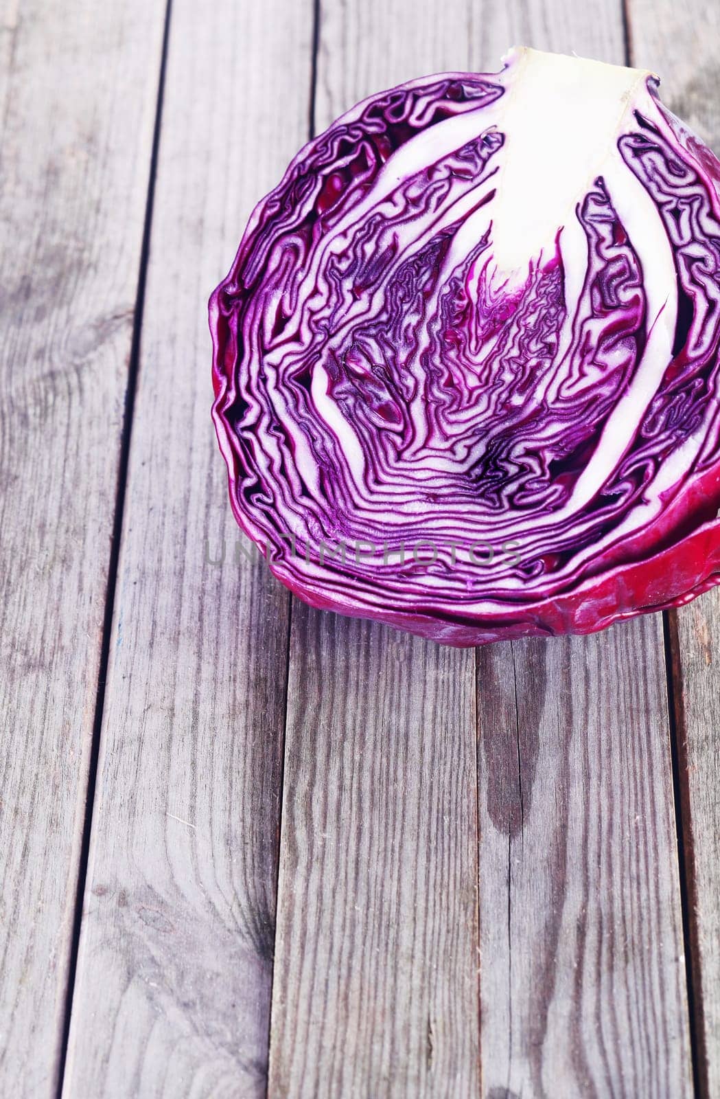 Close up Slice of Healthy Red or Purple Cabbage on Top of Wooden Platform. Emphasizing Copy Space.