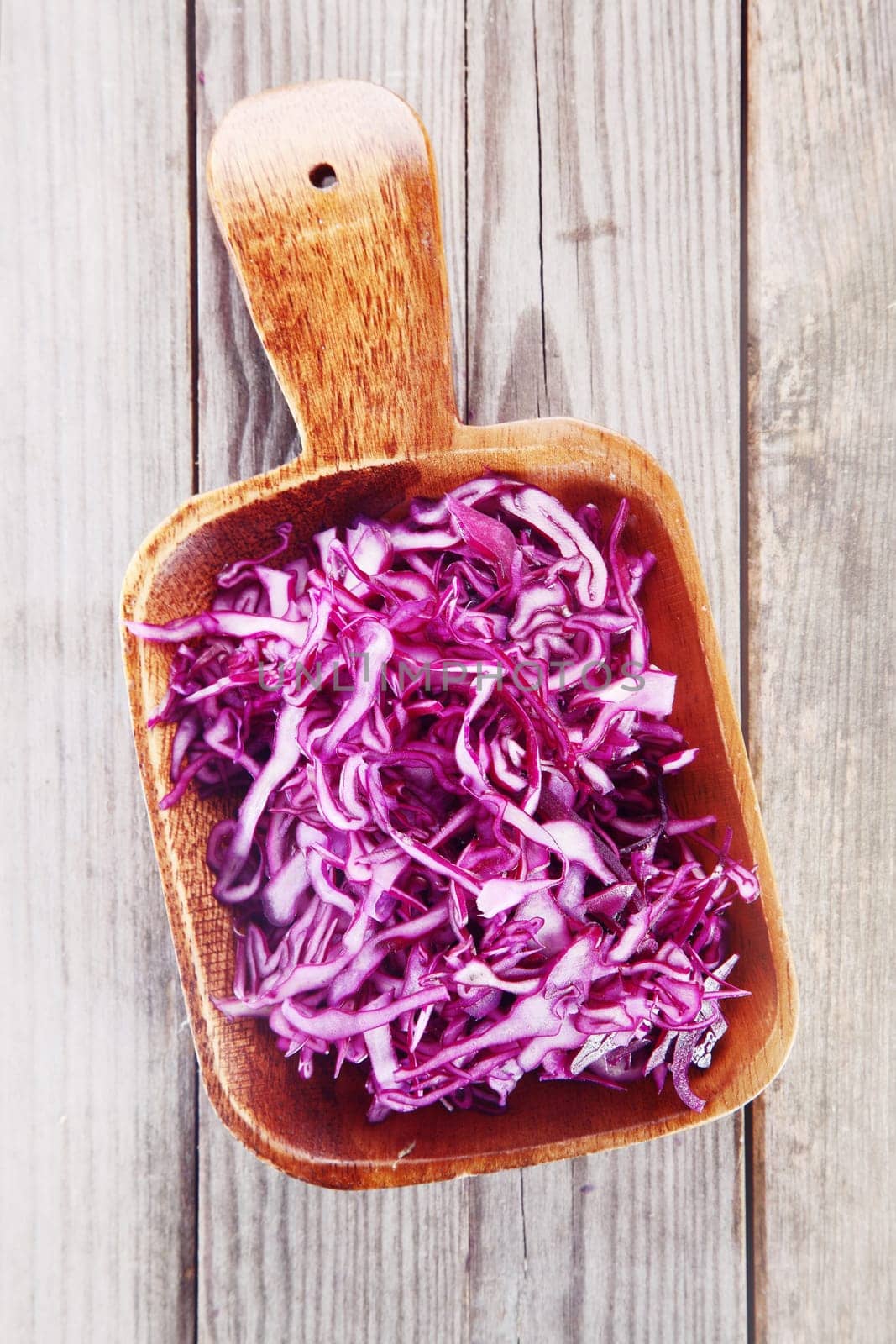 Close up Healthy Fresh Shredded Purple Cabbage on Wooden Bowl on Top of Wooden Table.