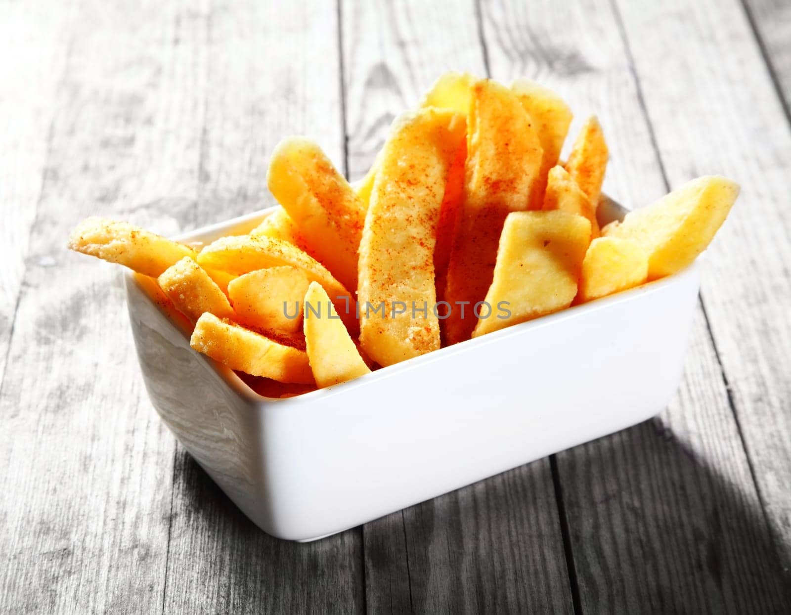 Close up Salted Fried steak French Fries on White Bowl, Placed on Gray Wooden Table.