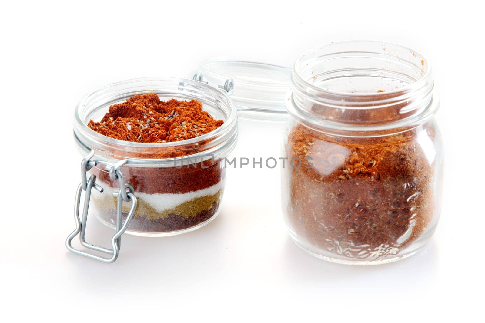 Close up Rub and Marinade Powder on Glass Jars, Isolated on White Background.