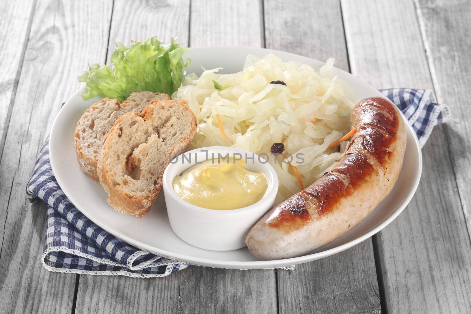 Close up Fresh Vegetable Salad and Sausage on White Plate with Bread and Mustard Sauce, Placed on Wooden Table.