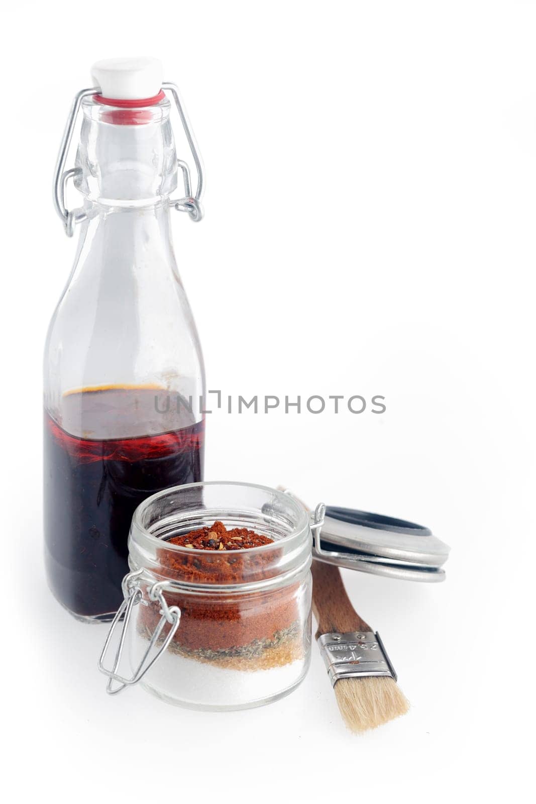 Close up Spicy Sauce and Powders for Recipe on Transparent Glass Containers with Brush. Isolated on White.