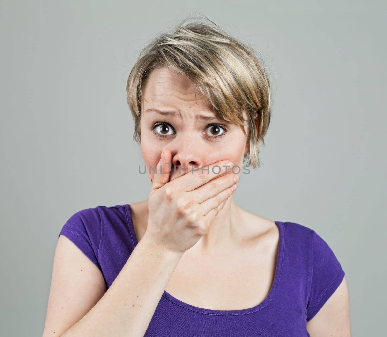 Young woman looking disturbed by something, isolated on white
