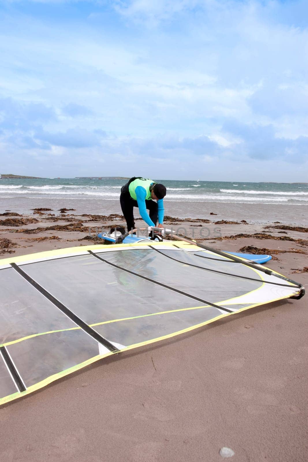 windsurfer getting equipment ready on the beach in the maharees county kerry ireland