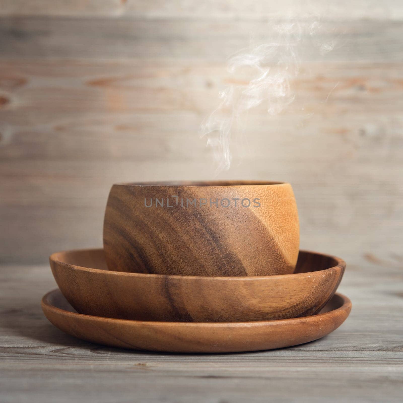 Empty bowl with hot steams on old wooden table. Dramatic light.