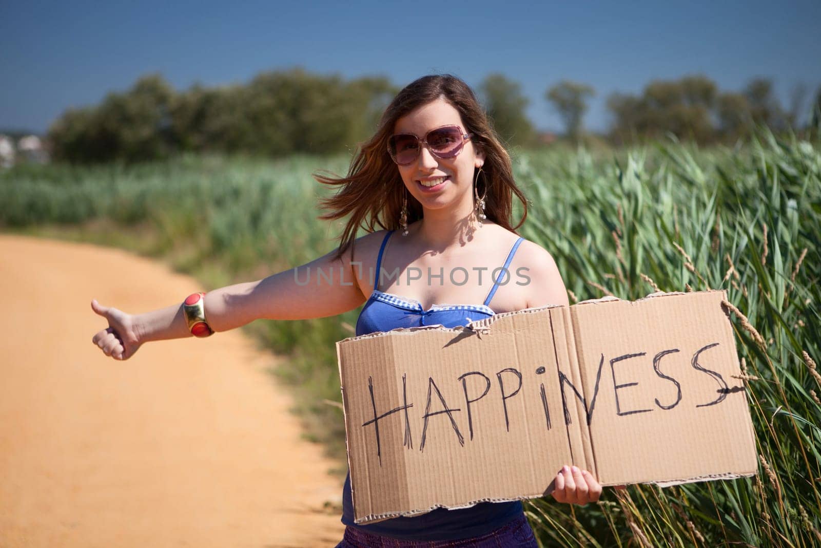 Pretty young woman holding happiness card