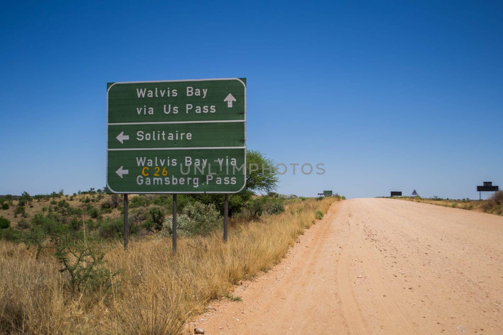 Solitaire, Namibia, November 2012: Namibian gravel and dirt road with directional sign to Walvis Bay and Gamsberg