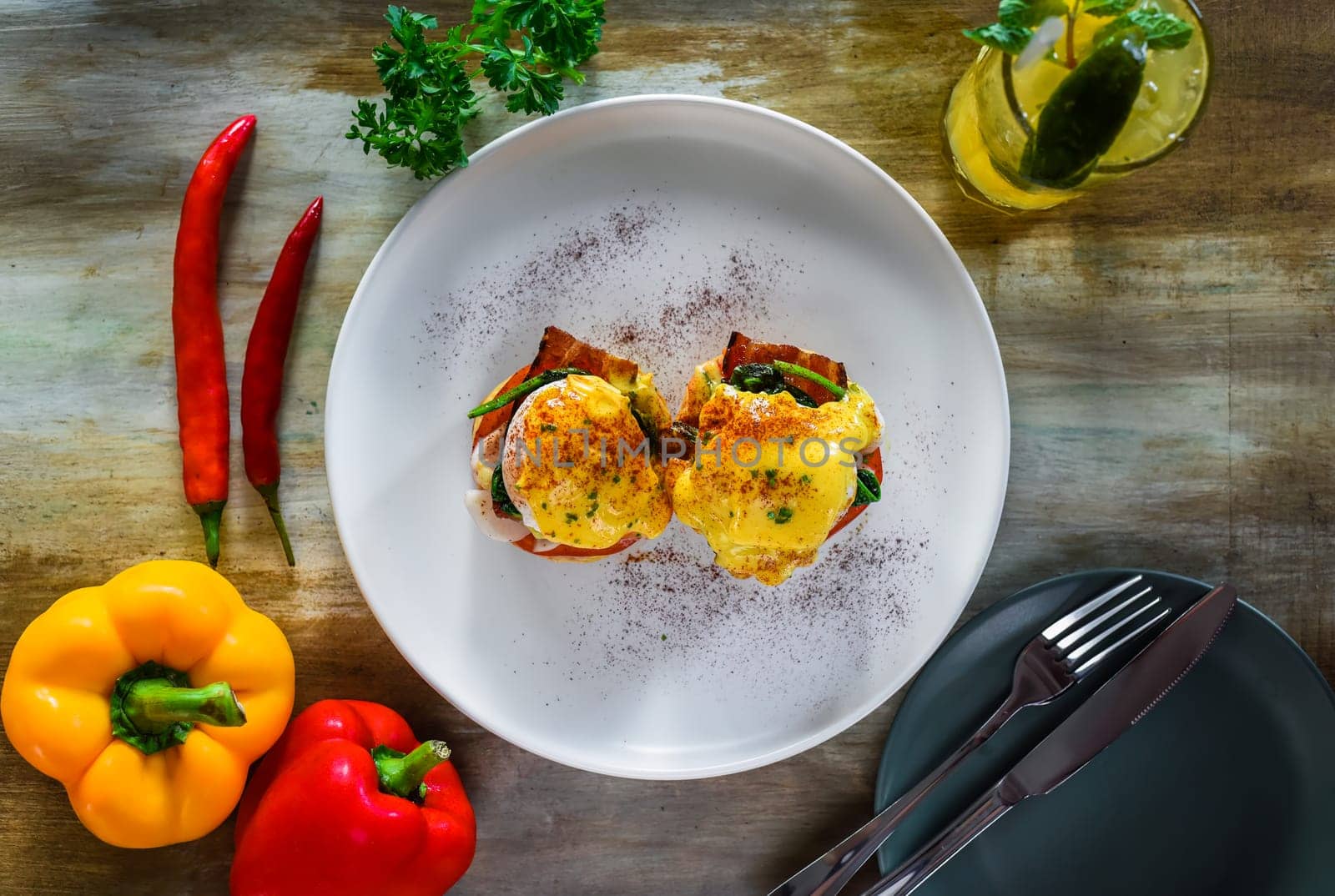 English muffin with poached eggs, bacon and Hollandaise sauce with vegetables