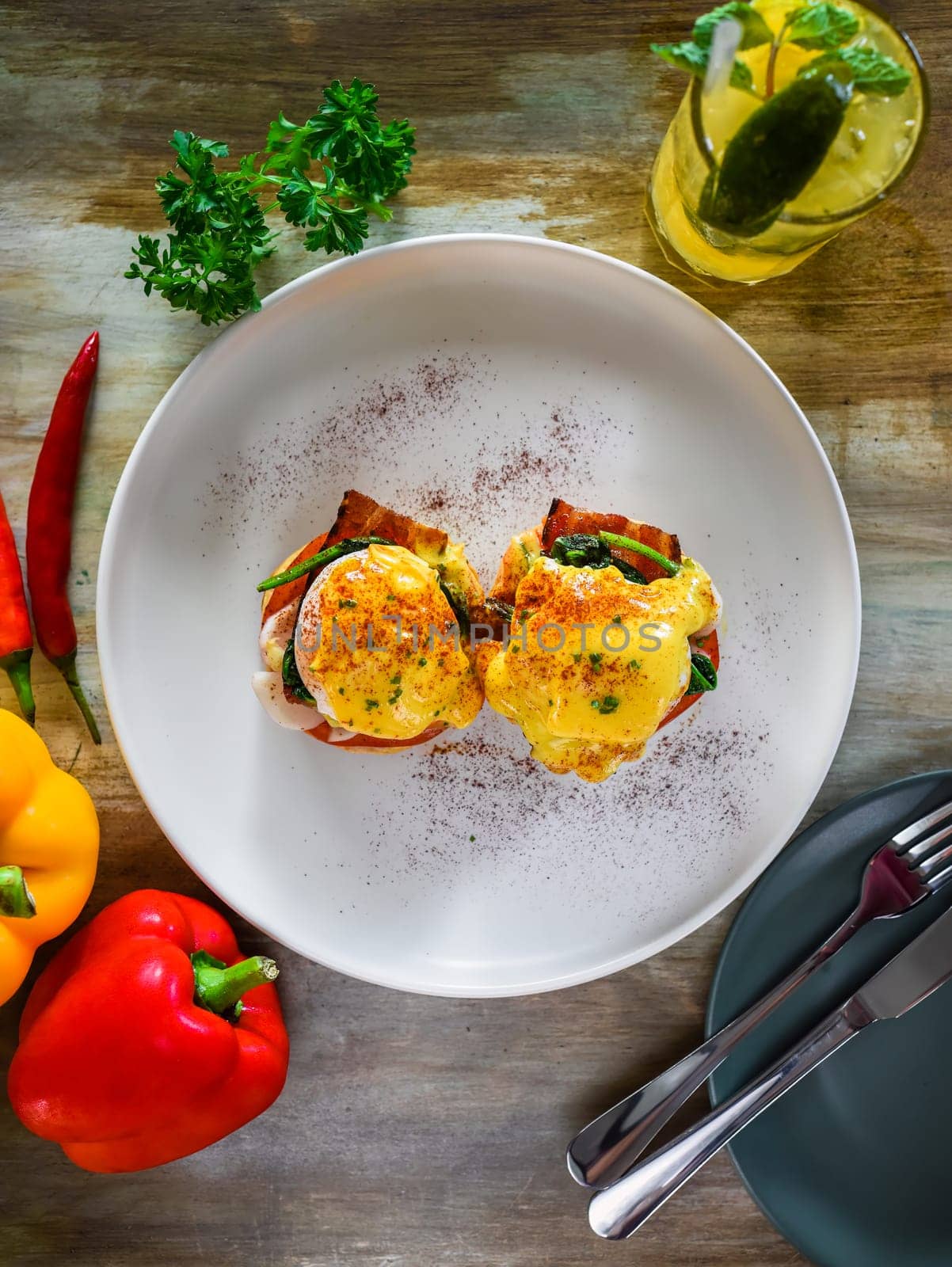 English muffin with poached eggs, bacon and Hollandaise sauce with vegetables