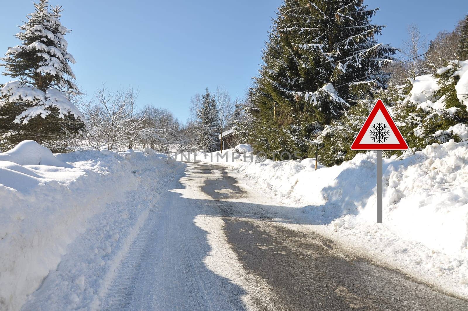 Warning sign at snow-covered road in Bavaria