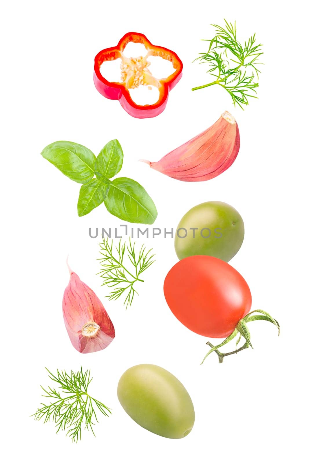 Isolated vegetables. Mixed tomatoes, dill, green olives, basil, bell pepper and garlic falling down on white with clipping path as package design element. Full depth of field.