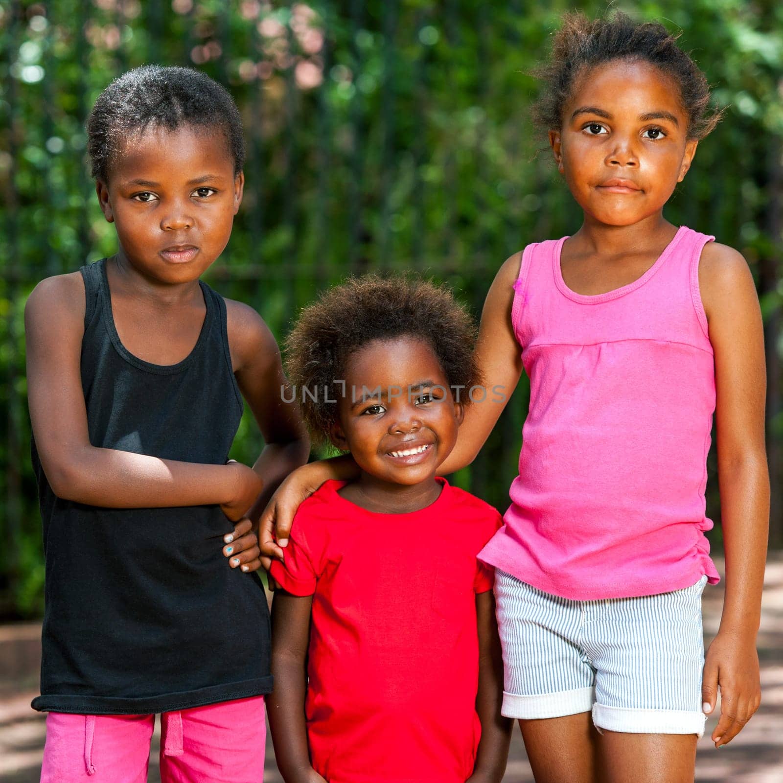 Portrait of three cute young african girls standing together outdoors.