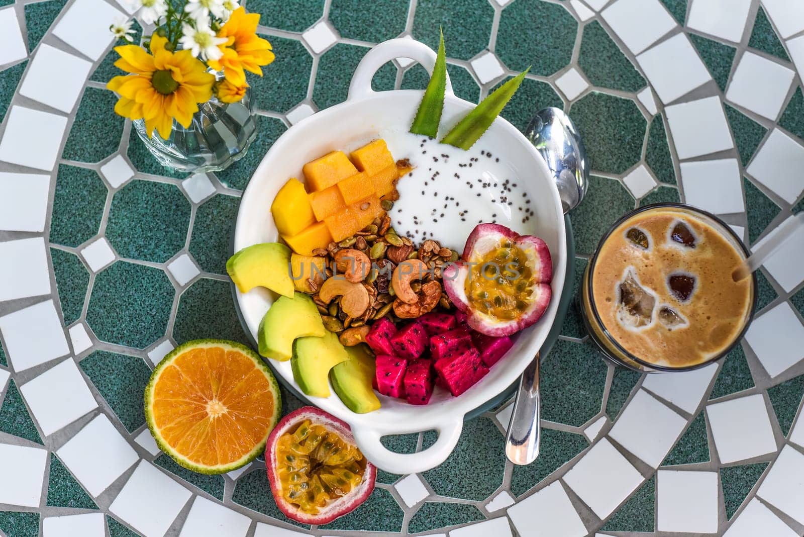 Granola with greek yogurt, honey, fresh fruits, chia seeds served with ice americano