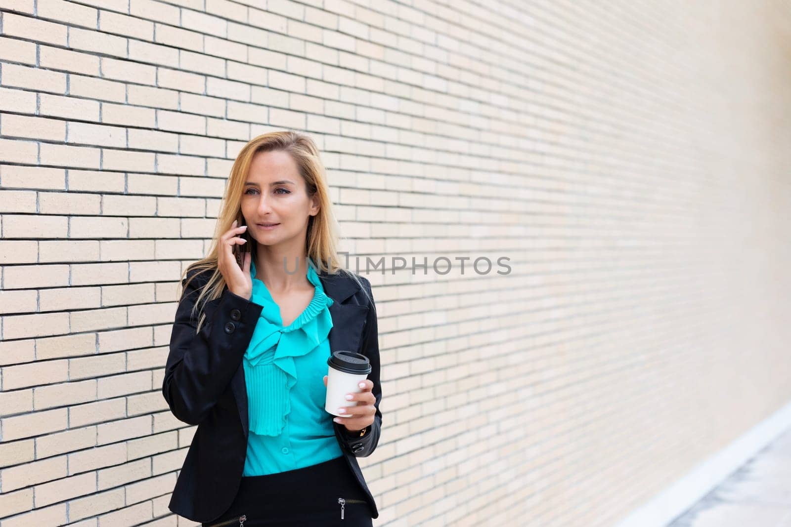 Successful businesswoman or entrepreneur talking on cellphone while outdoor. City business woman working.