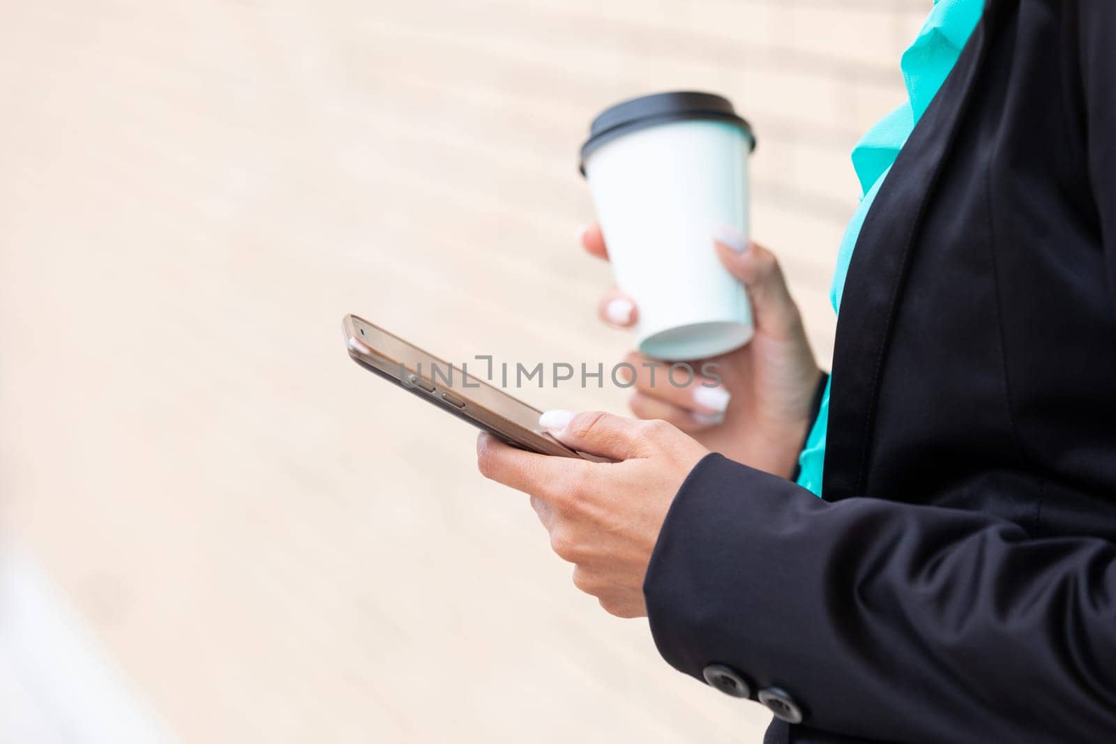 Business woman with coffe and talking on the phone near office